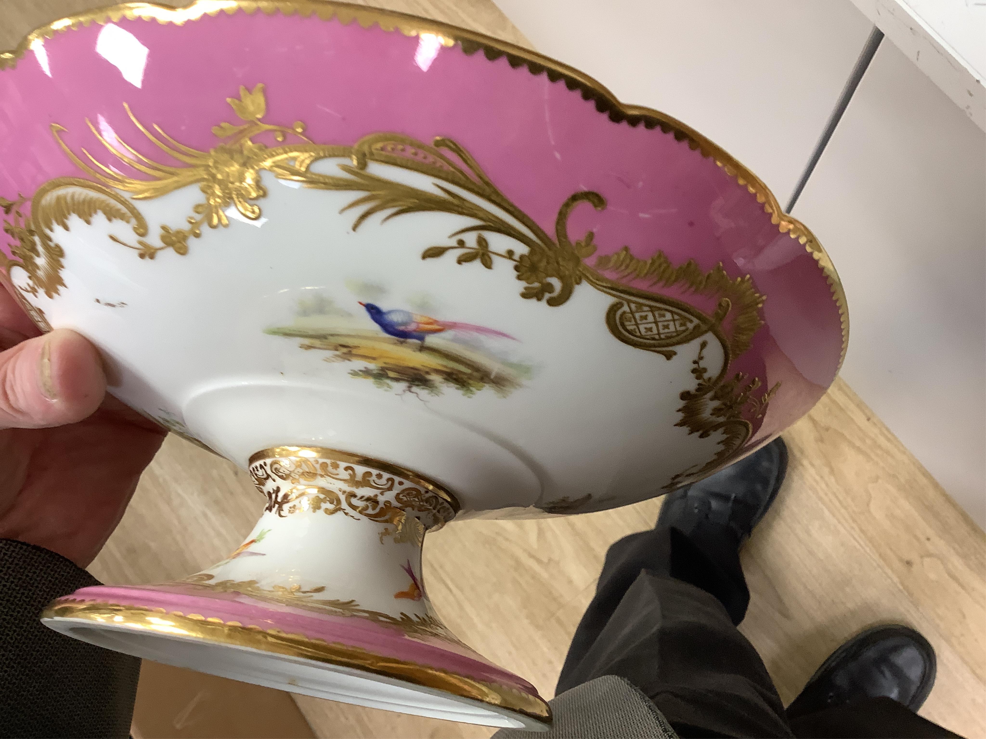 A Minton pink ground dessert service, in Sevres style, c.1850, hand painted with birds, comprising four comports and ten dessert plates, 23cm in diameter